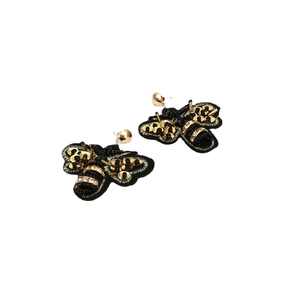 Exaggerated handmade fabric bee earrings with black beads and gold sequins on white background