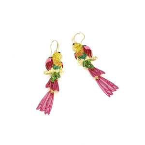 Détail de boucles d'oreilles perroquet avec strass colorés et branches en métal doré