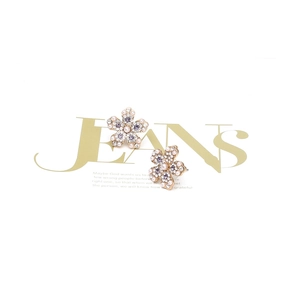 Détail de boucles d'oreilles fleurs avec perles blanches et cristaux lilas sur or