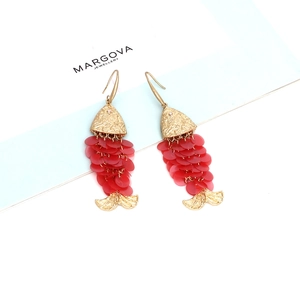 Detail of handmade fish-shaped drop earrings with golden metal and red sequin scales