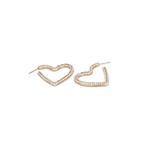 Détail macro de boucles d'oreilles cœur en alliage doré avec strass blancs pavés