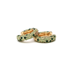 Boucles d'oreilles créoles dorées en U avec strass verts sertis sur fond blanc pur