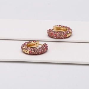 Détail de créoles en U dorées avec pavé de strass en cristal rose et rouge brillant