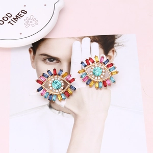 Detail of colorful Evil Eye stud earrings with radiant crystal rhinestones and blue center stone