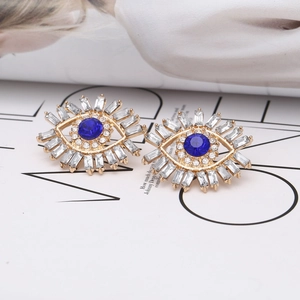 Detailed view of evil eye earrings featuring blue rhinestone and radiant crystals
