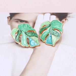 Detailed view of colorful enamel monstera leaf earrings with gold-plated alloy finish