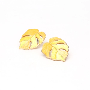 Detail of Monstera leaf earrings with yellow enamel finish and rose gold coating