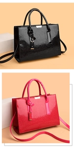 Close-up of black and pink tote bags featuring glossy crocodile embossed texture and metal plate