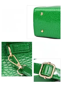 Macro view of green crocodile pattern tote with polished gold hardware and strap clips