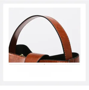 Close-up of retro oil wax leather handle and stitching detail on a brown tote bag