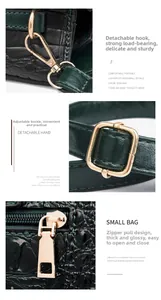 Detail of dark green crocodile texture bag with gold hooks and adjustable metal buckles