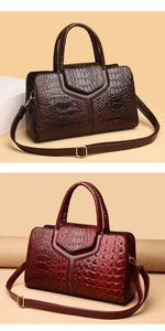 Detail view of large crocodile embossed tote bags in coffee and burgundy colors