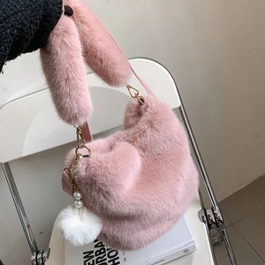 Pink plush faux fur bucket bag with pearl charm on a minimalist white background