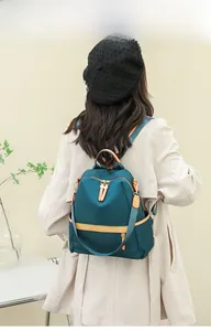 Rear view of a stylish waterproof nylon backpack in dark teal and yellow contrast colors