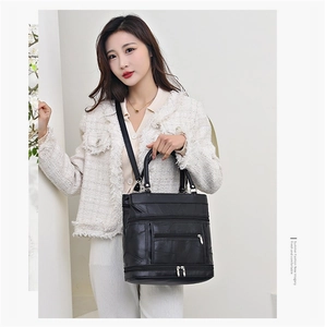 Detailed view of black faux leather tote featuring diamond stitching and multi-zipper pockets