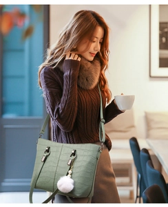 Detailed close-up of bean green embossed stone pattern bucket bag with soft pearl chain