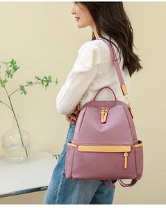 Detail view of the lotus pink nylon backpack with adjustable straps and yellow zipper pulls