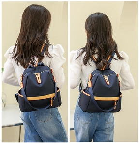 Detail of waterproof navy nylon backpack with yellow trim and side storage pockets