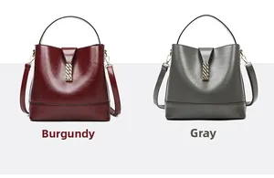 Detail of burgundy and grey leather bucket bags with gold chain buckles and straps