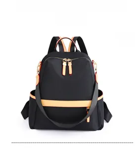 Front view of black nylon backpack featuring orange contrast trim and gold zippers
