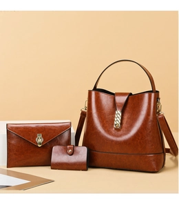 Detailed view of three-piece vintage brown faux leather bucket bag and envelope clutch set