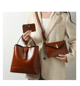 Close-up of three-piece vintage brown tote bag set with oil wax texture and metal buckle
