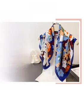 Detail eines seidenähnlichen quadratischen Tuchs mit Blumenprint und blauem Rand