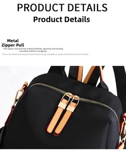 Close-up of black nylon backpack featuring smooth gold metal zippers and leather pullers