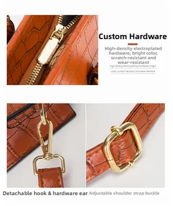 Detail der goldbeschichteten Hardware und Krokoprägung auf brauner Ledertasche