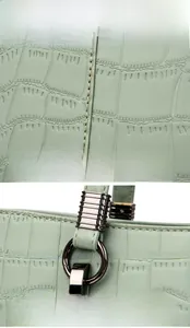 Detail view of light green crocodile embossed leather with dark gunmetal hardware accents