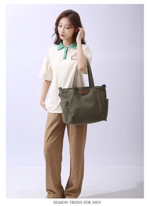 Detail view of a large green canvas tote bag with a minimalist front label for daily use