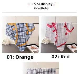 Detail view of plaid square scarves in orange and red with chain and rabbit art prints