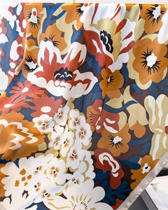 Makroaufnahme der Seidenschal-Textur mit detaillierten floralen Vintage-Mustern in warmen Tönen