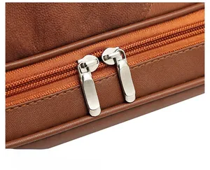 Detail of silver dual hardware zippers on vintage brown leather tote bag with fine stitching