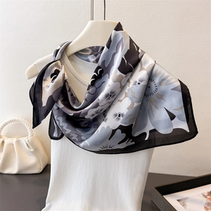 Detail eines eleganten bedruckten Seidenschals mit hochwertigen abstrakten Blumenmustern