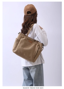 Detail of khaki canvas tote bag showing durable texture and minimalist logo tag