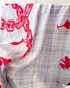 Detail of silk-like scarf featuring grey plaid pattern and bold red chain prints