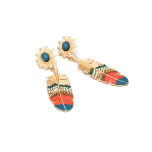 Detailed shot of bohemian feather drop earrings with blue beads and colorful crystals