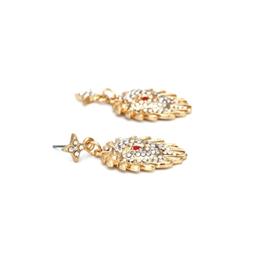 Boucles d'oreilles tête de lion dorées avec pavé de cristaux blancs et yeux rouges