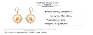 Gros plan de boucles d'oreilles perles baroques avec gouttes dorées géométriques