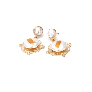 Détail de boucles d'oreilles en perles baroques avec métal martelé doré et finitions or