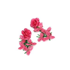 Boucles d'oreilles rose avec fleurs en perles faites main et pompons sur blanc