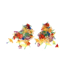 Macro shot of colorful acrylic flower clusters and leaf tassels on bohemian earrings