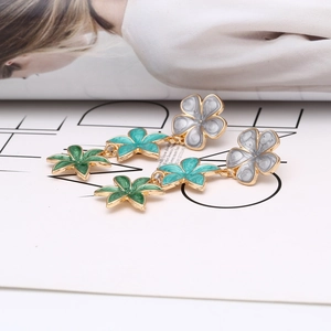 Detail of colorful enamel floral drop earrings with a gradient of grey and green flowers