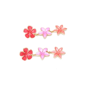 Detailed macro view of triple floral earrings with colorful enamel petals and gold edges