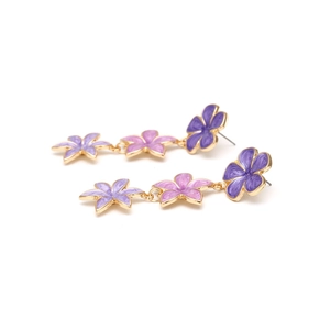 Detailed view of layered purple enamel flower drop earrings with golden metal frames
