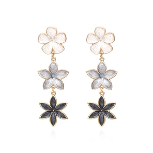 Detailed view of triple-layered floral drop earrings with gradient grey and gold edges