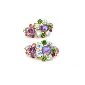 Détail de boucles d'oreilles géométriques aux cristaux colorés et strass sur métal doré