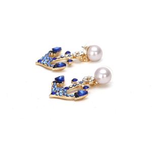 Nautical gold anchor earrings with blue rhinestones and pearls on white background