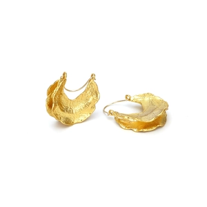 Elegant gold-tone metal leaf pendant earrings with textured surface on white background